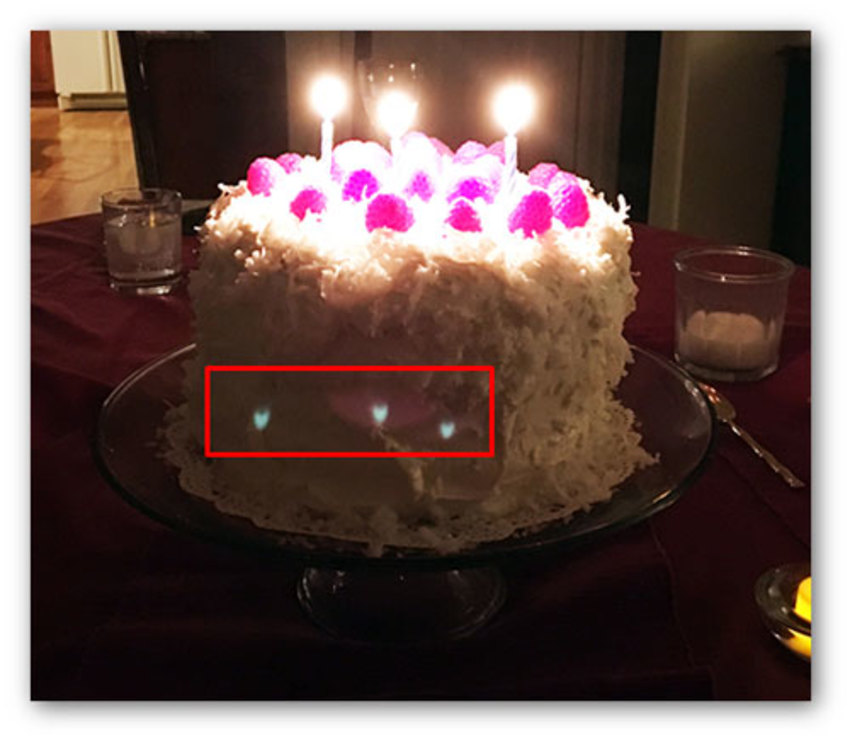 Ghost example: Picture Photo taken with a cell phone camera that clearly shows three sharply focused ghost images of the candle flames. There is also a fourth, extended ghost image centered on the middle sharp ghost image. | Synopsys