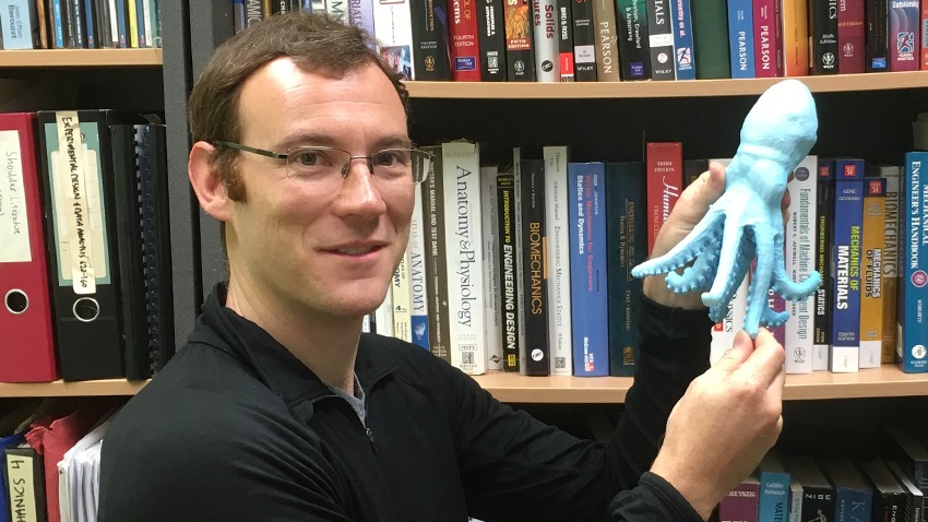 : Dr. Ackland holding a 3D printed octopus